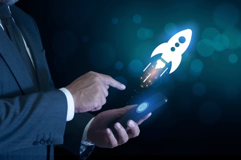 Businessman push button startup rocket or rocket ship launch on mobile phone or smartphone. idea of successful business project start up